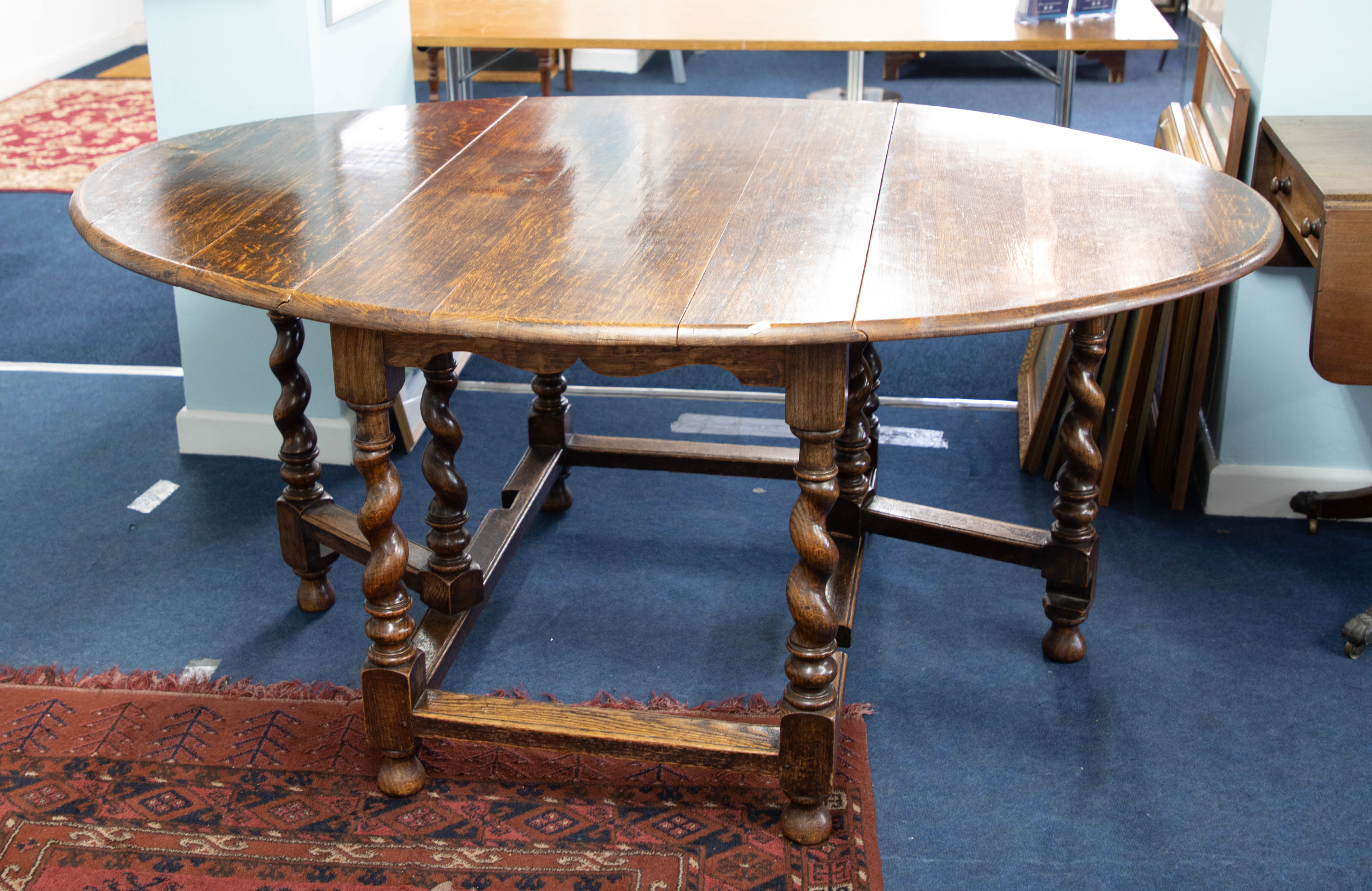 An oak gate-leg table with barley twist legs, together with a set of eight upholstered dining chairs