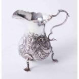Antique silver cream jug with embossed bird and scroll decoration to body on 3 raised padded feet