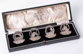 A boxed set four Geo V silver menu holders, depicting fish, dogs and fisherman, the cased marked '