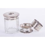 A silver and glass string box, a silver serviette ring and a silver lidded glass dressing table