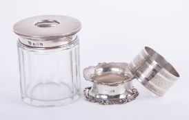 A silver and glass string box, a silver serviette ring and a silver lidded glass dressing table