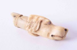 A 19th century whistle, carved ivory, in the form of a dogs head, length approximately 45mm.