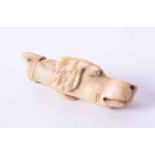 A 19th century whistle, carved ivory, in the form of a dogs head, length approximately 45mm.