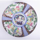 An oriental porcelain charger decorated with panels of figures, exotic birds, gilt work on a blue