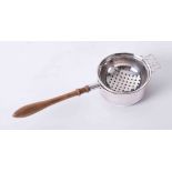 Solid silver tea strainer and stand with decorative pierced bowl, wooden shaped handle and