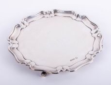 A Geo V silver waiter, maker 'W.L' on scroll feet, with a gadrooned border, diameter 21cm, 10.70oz.