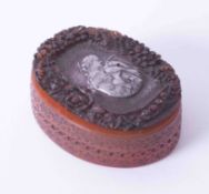 A French carved amber box and cover, the lid inset with a white coloured metal panel, signed 'L.P