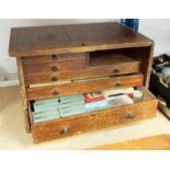 A fitted table top cabinet containing various pocket watchmakers bits including cylinders, small