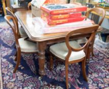 A mahogany dining table with a central insertable extension leaf with original winding handle height