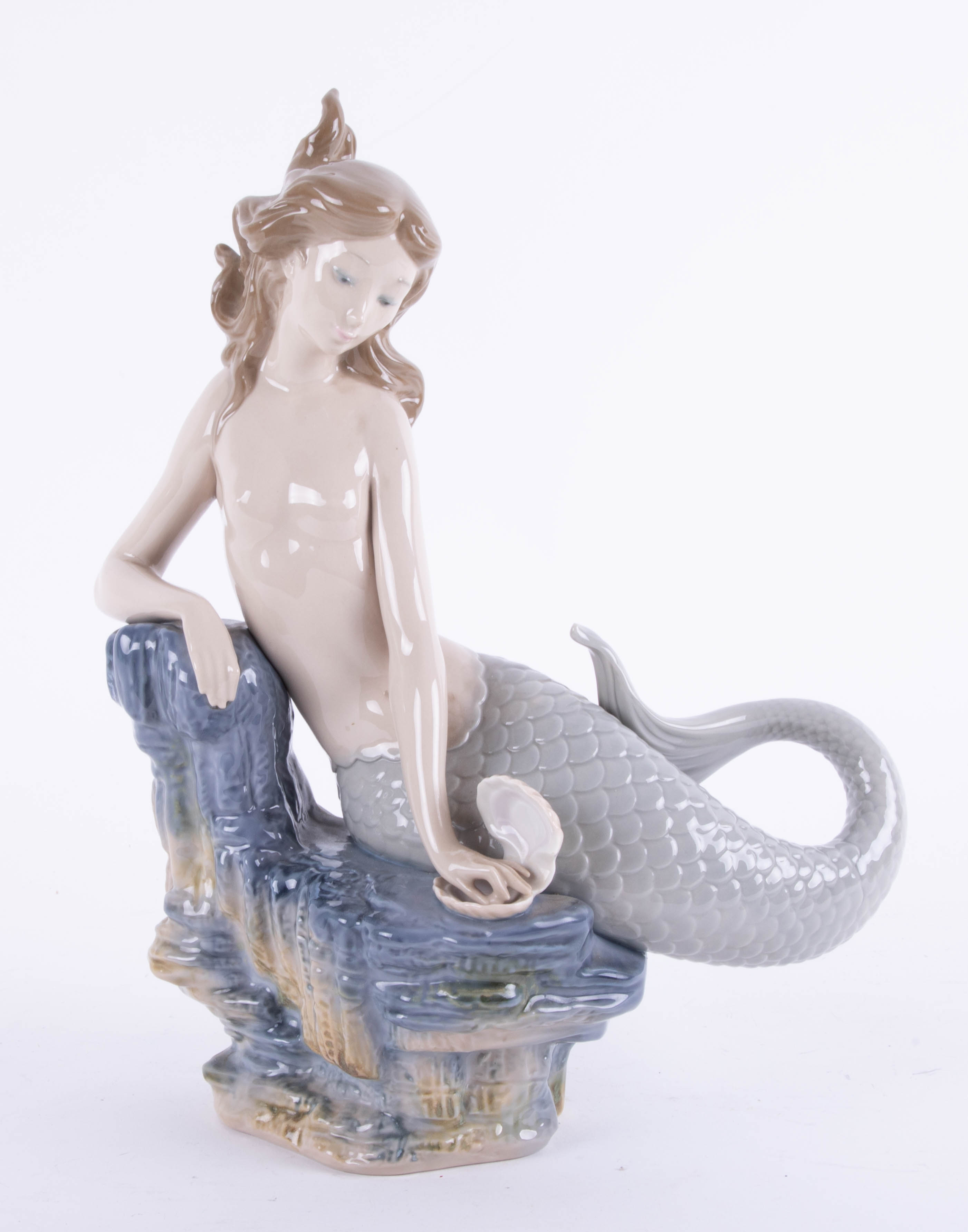 Lladro, a porcelain figure of a Mermaid on a rocky base, height 30cm.