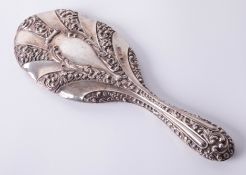 A silver hand mirror with heavy embossed scroll and ribbed decoration, mirror in good condition,