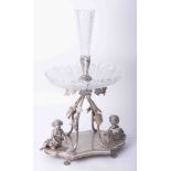 A silver plated table centrepiece, with glass fittings, decorated with vines, grapes, cherubs,