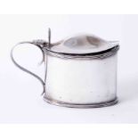 A George V silver mustard pot with blue glass liner, height 7cm, 210g.