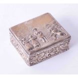 A George V silver & gilt square box, decorated in relief with figures in a landscape on the lid