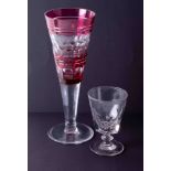 A large Bohemian? Cranberry glass goblet, height 28cm together with a drinking glass early 20th