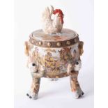 A Japanese Satsuma box and cover with cockerel finial and figure legs, height 21cm.