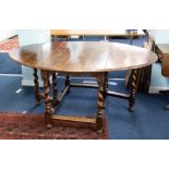 A large heavy oak gate-leg dining table with barley twist legs, together with a set of eight