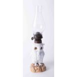 A white porcelain owl oil lamp with glass eyes, height including glass chimney 36cm.