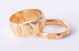 A pair of 22ct yellow gold wedding bands, one wide patterned band 8.3g and a narrower patterned band