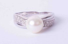 A modern 18ct white gold ring set cultured pearl, approx. 12mm, with small diamonds set to the