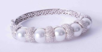 An impressive 18ct white gold pave set diamond and pearl set bangle.