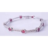 An 18ct white gold and ruby fancy bracelet, set approx. 3.15 carats of oval cut rubies interspaced