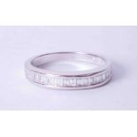 An 18ct white gold half eternity ring channel set with baguette cut diamonds, finger size Q.