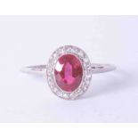 A platinum cluster ring set oval ruby approx. 0.65 carat, surrounded by diamonds in a milgrain