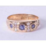 An 18ct yellow gold diamond and sapphire set ring in a gypsy style setting, finger size M.