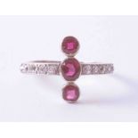 A 18ct white gold & platinum ring set three rubies approx. 0.55 carat total weight, in a cross