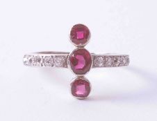 A 18ct white gold & platinum ring set three rubies approx. 0.55 carat total weight, in a cross