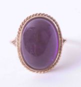 A large 9ct yellow gold ring set an oval cabochon amethyst, 6.6g, finger size O.