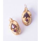 A pair of ornate yellow gold Continental style earrings set almandine garnet with leaf design and