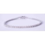 An 18ct white gold claw set diamond line bracelet, total weight approx. 3 carats, length 18cm.