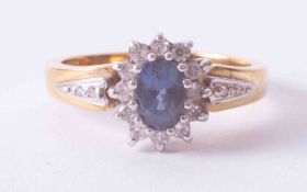 An 18ct yellow gold cluster ring set oval cut sapphire and diamonds with small diamonds on the