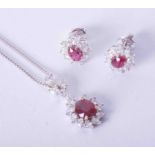 A fine 18ct white gold flower shaped ruby & diamond pendant & chain with a pair of matching