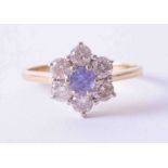 An 18ct yellow gold flower style cluster ring, set with a central tanzanite (approx. 0.25cts) and