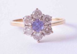 An 18ct yellow gold flower style cluster ring, set with a central tanzanite (approx. 0.25cts) and