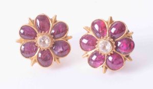 A pair of antique high carat gold Indian flower design ear lobe plugs set with cabochon cut ruby