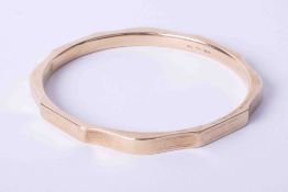 A 9ct yellow gold hollow hexagonal slave bangle with engraving to the outer edges, 19.9g.