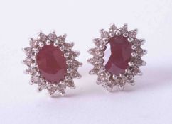 A pair of 9ct yellow & white gold cluster earrings set oval rubies & small diamonds, approx. 3.5g.