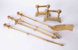 A three piece polished brass fire companion set and a pair of matching fire dogs.