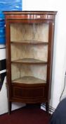 An Edwardian mahogany and inlaid corner cabinet with serpentine outline, fitted with single door.