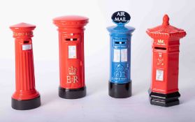 Four Royal Mail money bank models of post boxes.