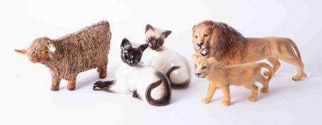 A Beswick Lion cub, a pair of Siamese cats together with a Highland bull, damaged, (5 items).