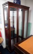 A modern two door display cabinet, fitted with glass shelves, mirror interior and internal lights,