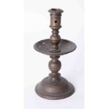 An antique Dutch brass single candlestick with wide drip tray, height 22cm.