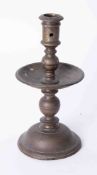 An antique Dutch brass single candlestick with wide drip tray, height 22cm.