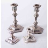 A pair of silver short desk candlesticks together with a pair of silver plated candlesticks.