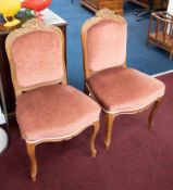 A pair of carved walnut framed bedroom chairs with cabriole legs and upholstered seats and backs.